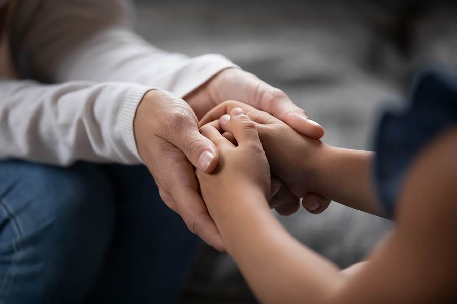 Empathic mom holding child's hands